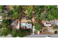 Expansive aerial view showcasing the property's layout, mature trees, pool, buildings, and defining boundaries at 308 Sunnyside Dr, Leesburg, FL 34748