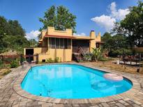 Swimming pool, yard and exterior of home showing stucco finish at 308 Sunnyside Dr, Leesburg, FL 34748