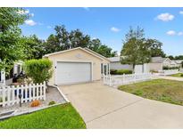 Inviting single-Gathering home with a white picket fence and attached one-car garage at 3472 Roanoke St, The Villages, FL 32162