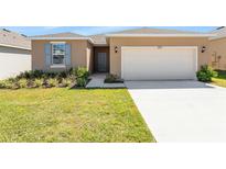 Charming single-story home featuring a two-car garage and well-manicured front lawn at 4998 Abigail Dr, Lake Wales, FL 33859