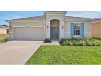 Charming single-story home with a two-car garage, well-maintained lawn and beautiful, complimentary landscaping at 524 Silver Palm Dr, Haines City, FL 33844