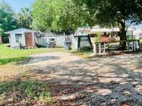 Property with ample parking space in a yard with trees, shrubs, and a clearly visible house number at 5809 County Road 547 N, Davenport, FL 33837