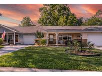 Charming single-story home featuring a well-maintained lawn, garage, and inviting front porch at 8738 Sw 95Th Ln # B, Ocala, FL 34481