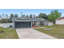 Charming single-story home featuring a well-manicured lawn, brick accents, and an attached two-car garage at 2304 Clementine Trl, Clermont, FL 34714