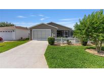 Charming home with a one-car garage, a screened-in porch, and a manicured front lawn at 2348 Riley Rd, The Villages, FL 32162