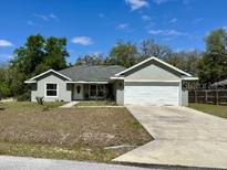 Charming single-story home with a spacious driveway and a well-maintained lawn at 254 Locust Pass Dr, Ocala, FL 34472