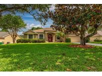 Landscaped single-story home with manicured lawn, palm trees, and charming stone accents at 3141 Brighton Rd, Eustis, FL 32726