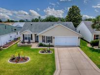 Charming single-story home with a well-manicured lawn and two-car garage on a sunny day at 3432 Fairfield St, The Villages, FL 32162