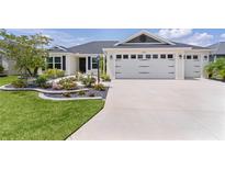 Charming single-story home with a well-manicured lawn, a two-car garage, and beautiful landscaping at 3745 Causey Ct, The Villages, FL 32163