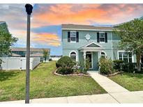 Charming two-story home with landscaped front yard and walkway leading to a covered porch at 534 Juniper Springs Dr, Groveland, FL 34736