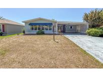 Charming single-story home with covered parking and well-maintained front yard at 608 Saint Andrews Blvd, Lady Lake, FL 32159