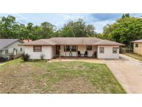 Charming single-story home with a covered front porch and a well-maintained lawn at 800 Jefferis Ct, Eustis, FL 32726
