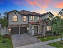 Stunning two-story home featuring a tile roof, brick accents, and a paver driveway at 8530 Vivaro Isle Way, Windermere, FL 34786