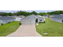 Charming single-story home featuring a three-car garage and well-maintained lawn at 8978 Se 42Nd Ct, Ocala, FL 34480