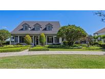 Beautiful exterior showcasing a well-maintained lawn and landscaped garden in front at 9648 Weatherstone, Windermere, FL 34786