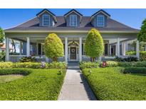 Charming home with a lush front yard and welcoming porch with columns at 9648 Weatherstone, Windermere, FL 34786