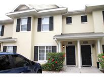 Inviting two-story townhome featuring black shutters, a well-maintained landscape, and visible unit numbers at 10115 Regent Park Dr # 2503, Orlando, FL 32825