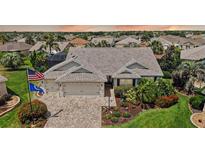 Charming home with a 3-car garage, meticulously landscaped yard, and brick-paved driveway in a lush community at 1053 Alcove Loop, The Villages, FL 32162