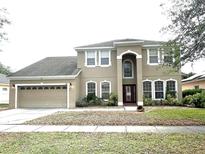 Charming two-story home with a manicured lawn and a two-car garage at 108 Whispering Pines Way, Davenport, FL 33837