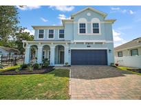 Charming two-story blue home with a brick driveway and well-manicured landscaping in a lovely neighborhood at 1155 Dora Parc Ln, Mount Dora, FL 32757