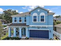 Charming two-story home with a covered front porch and a brick paver driveway leading to the garage at 1155 Dora Parc Ln, Mount Dora, FL 32757
