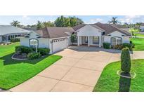Beautiful home showcasing a large driveway, attached garage, and well-manicured lawn at 12118 Se 175Th Loop, Summerfield, FL 34491