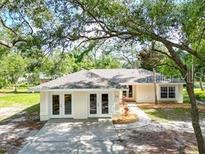 Charming single-story home with double doors, light-colored exterior, and mature landscaping at 1725 14Th St, Orange City, FL 32763