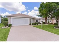 Charming single-story home with a well-maintained lawn and a two-car garage at 1813 Caryle Ln, The Villages, FL 32162