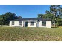 Charming single-story home featuring stucco siding, black trim, and a well-manicured lawn at 2 Pine Terrace Way, Ocala, FL 34472