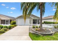 Charming single-story home with a two-car garage, landscaped front yard, and inviting curb appeal at 2457 Upton St, The Villages, FL 32163
