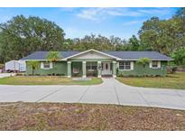 Charming single-story home with a manicured front yard, complemented by fresh exterior paint and mature landscaping at 39812 French Rd, Lady Lake, FL 32159