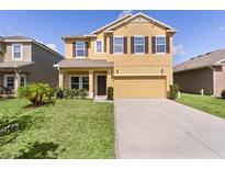 Charming two-story home with a well-maintained lawn and a two-car garage, perfect for Gathering living at 422 Rock Springs Cir, Groveland, FL 34736