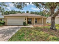 Charming single-story home with a well-maintained lawn, a two-car garage and inviting front porch at 4314 Arlington Ridge Blvd, Leesburg, FL 34748