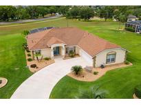 Stunning aerial view of home with a well-manicured lawn, appealing landscaping, and a screened-in pool area at 5400 Saddleback Ct, Lady Lake, FL 32159