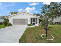 Charming single-story home featuring a two-car garage, screened front porch, and well-maintained landscaping at 5618 Rosewall Cir, Leesburg, FL 34748