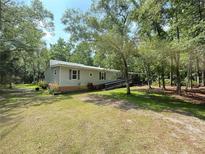 Charming single-story home with lush landscaping and a convenient access ramp nestled among mature trees at 606 Hamilton Dr, Orlando, FL 32833