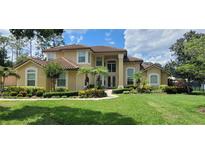 Stunning two-story home with a well-manicured lawn, lush landscaping, and beautiful curb appeal at 8719 Kenmure Cv, Orlando, FL 32836