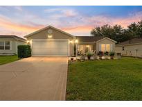 Charming single-story home with a well-manicured lawn and an attached two-car garage at 965 Eastmont Ct, The Villages, FL 32162