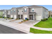 Charming townhomes featuring attached garages, manicured lawns, and neutral color schemes at 1042 Lido Dr, Howey In The Hills, FL 34737