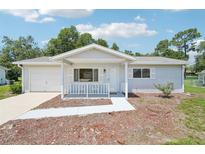 Charming single-story home featuring a cozy front porch and attached garage at 11214 Sw 77Th Ct, Ocala, FL 34476