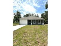 Charming single-story home with a well-maintained lawn, a two-car garage, and a cozy entryway at 13430 Sw 105Th Place, Dunnellon, FL 34432