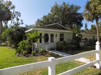 Charming single-story home with lush landscaping, a white picket fence, and an inviting entrance at 1485 Morningside Dr, Mount Dora, FL 32757