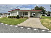 Charming single-story home with well-maintained lawn and covered carport at 152 Dogwood Trl, Leesburg, FL 34748