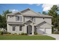 Charming two-story home with a manicured lawn and a two car garage on a sunny day at 1690 Cadence St, Minneola, FL 34715