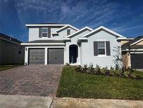 Charming two-story home with a brick driveway and well-maintained landscaping at 1881 Sunshine Peak Dr, Minneola, FL 34715