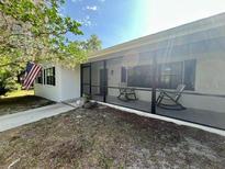 Welcoming screened-in porch with rocking chairs for relaxing and enjoying the outdoors at 2227 S Spring Garden Ave, Deland, FL 32720
