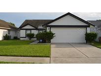 Charming single-story home featuring a well-manicured lawn and attached two-car garage at 3041 Bloomsbury Dr, Kissimmee, FL 34747