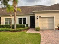 Well-maintained home with a two-car garage, neat landscaping, and a brick pathway to the front door at 3205 Sonesta Ct # B, Clermont, FL 34711