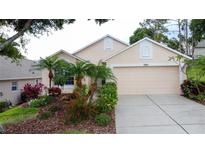 Charming single-story home with lush landscaping, palm trees, and a two-car garage at 3525 Rollingbrook St, Clermont, FL 34711