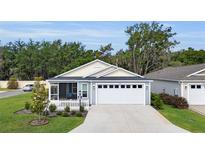 Charming single-story home boasts a well-manicured lawn, screened porch, and a two-car garage at 3984 Kanawha Pl, The Villages, FL 32163